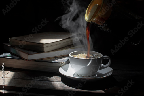 Coffee in a hot glass cup on a dark wooden floor