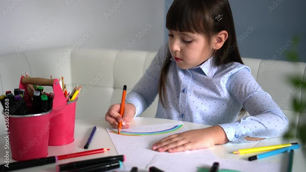 Kids creativity. Child little girl drawing rainbow with colored pencils on paper at home Kids creativity. Child little girl drawing rainbow with colored pencils on paper at home