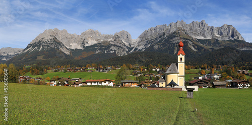 The parish church at the Going village with the famous mountain Wilder Kaiser at the background, Tirol, Austria photo