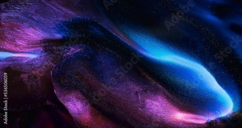 Lilac blue black dark paint abstract background. Dark purple violet ink splash wave spreads closeup. 4k sparkling liquid footage. Glitter Sequins shine in black acrylic fluid art. Space galaxy concept