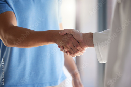 Handshake, trust and respect with a patient and medical worker or doctor shaking hands, greeting or introduction during consultation. Closeup of men with thank you gesture or welcome, agree or greet