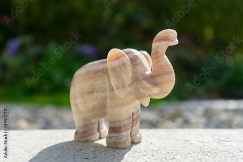 Elephant statue near house in front of garden.