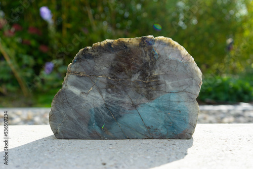 Labradorite mineral stone near house in front of garden.