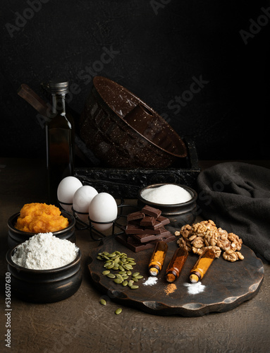 Ingredients for chocolate pumpkin cupcake on a dark background