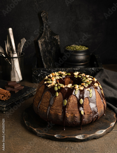 Chocolate pumpkin cupcake with chocolate icing on a dark background