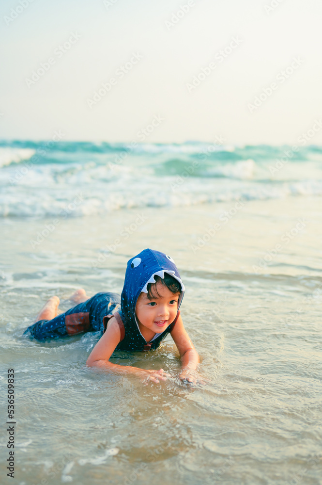 2 years old baby boy playing sand on the beach,Holidays with baby summer concept.