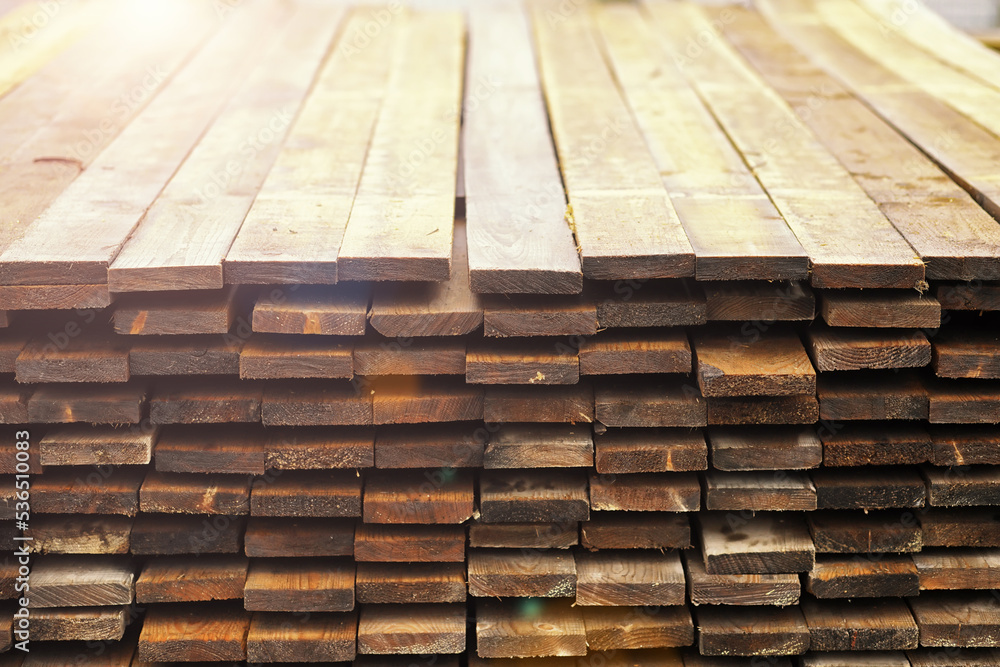 Stack of fresh pine boards in a sawmill warehouse. Harvesting, sale of lumber for construction Stack of fresh pine boards in a sawmill warehouse. Harvesting, sale of lumber for construction