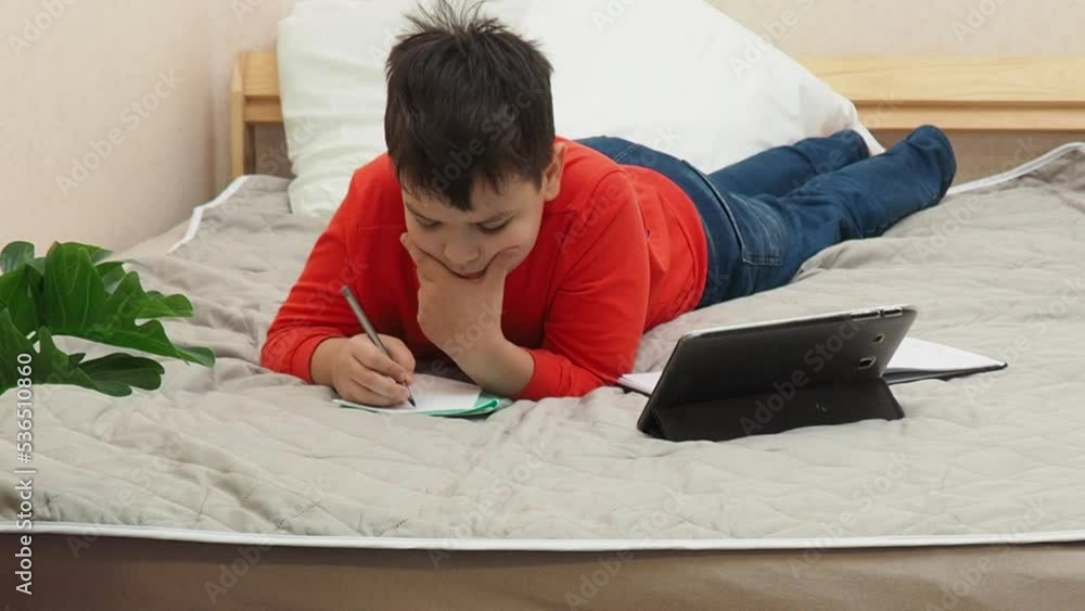 Back to School, Online learning, distance lesson, education at home, technology for schoolboy, business conference. Children doing homework at home. boy taking notes using a tablet.