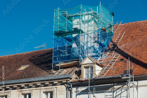 Obraz na płótnie La restauration d'une vieille cheminée sur un vieux toit d'un ancien bâtiment historique