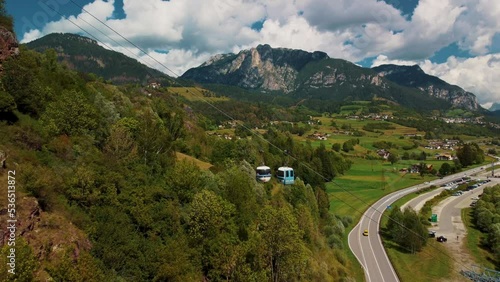 Alpe Cermis Risalita cable car in Italy, dolomites, mountain peaks and mountain river bellow. photo