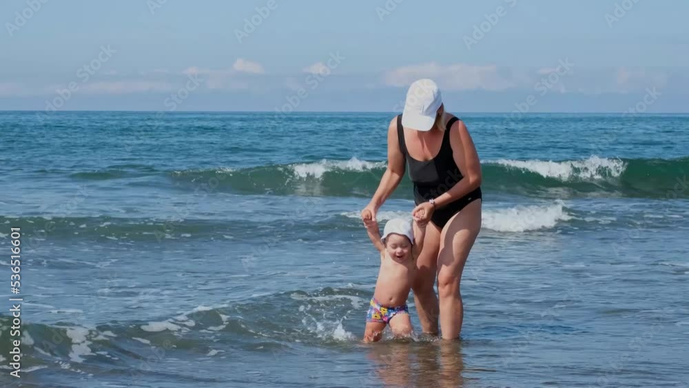 Mom with her little son in the sea on the waves. Mom with her little son in the sea on the waves.