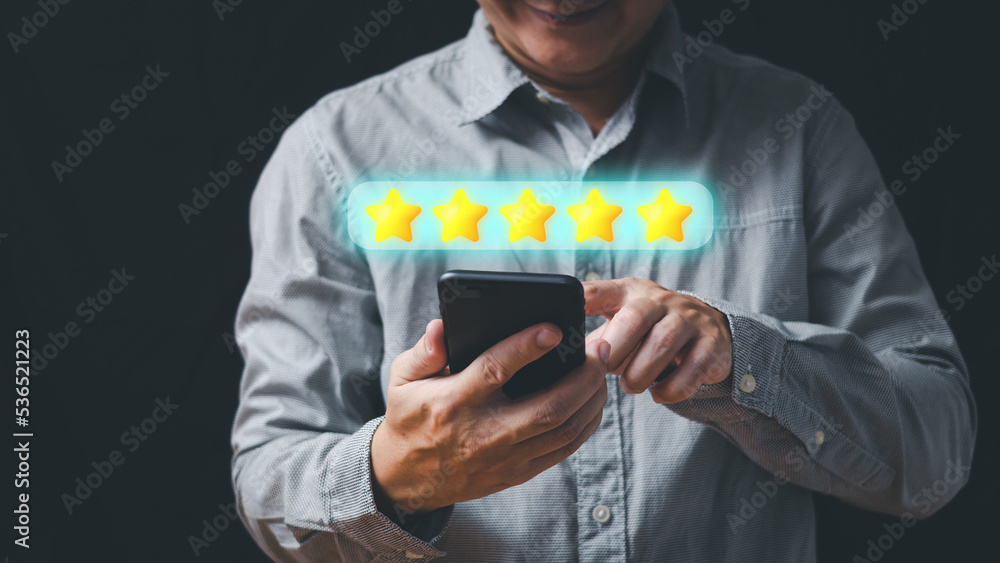 a businessman use smartphone select on the five star to give satisfaction in service.rating very impressed.Customer service and Satisfaction concept. a businessman use smartphone select on the five star to give satisfaction in service.rating very impressed.Customer service and Satisfaction concept.
