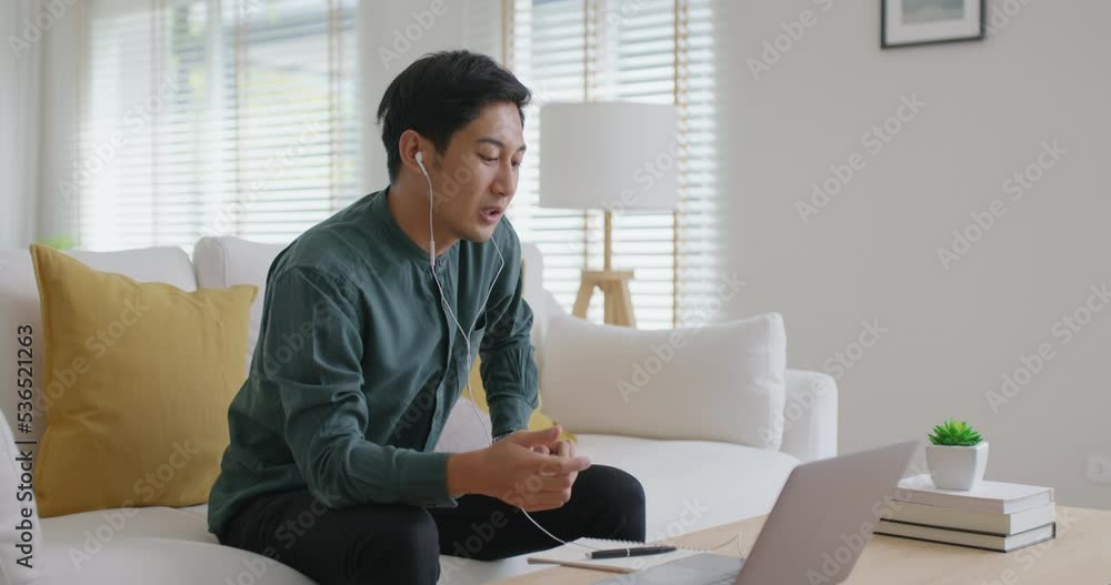 Gen Z asia people male guy work at home office sofa video call advice on laptop remote telework job online. Young adult hybrid worker man in reskill upskill career class look at webcam digital camera. Gen Z asia people male guy work at home office sofa video call advice on laptop remote telework job online. Young adult hybrid worker man in reskill upskill career class look at webcam digital camera.