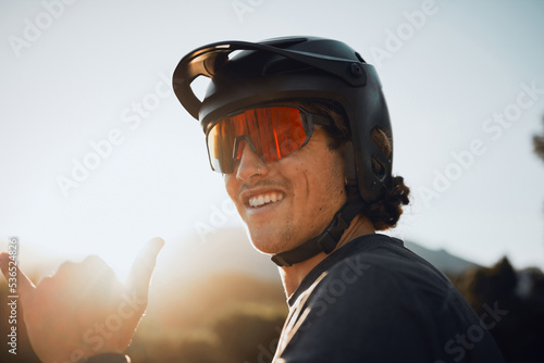 Mountain bike, nature and man cycling for fitness training in the mountains of Peru during summer. Portrait of a sports person with glasses during adventure in the countryside and hands sign © Clement C/peopleimages.com