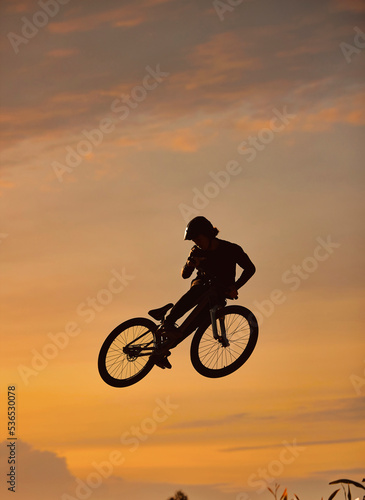 Mountain bike, cyclist and fitness jump at sunset in Colorado countryside nature in workout, exercise or training. Danger risk, extreme bmx sports or freedom cycling man in sunrise with stunt energy