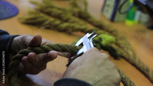 The male hands of an expert measure the rope with a caliper. Examination, research, murder weapon photo