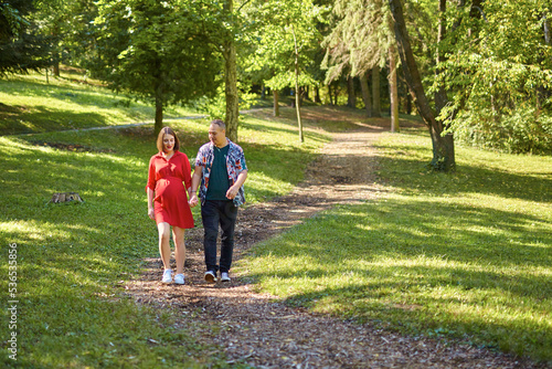 Lovely pregnant couple walking in a park