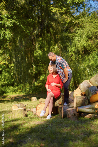 Lovely pregnant couple walking in a park