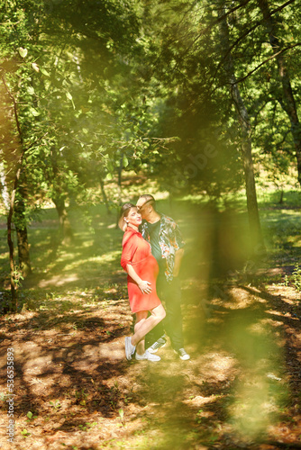 Lovely pregnant couple walking in a park