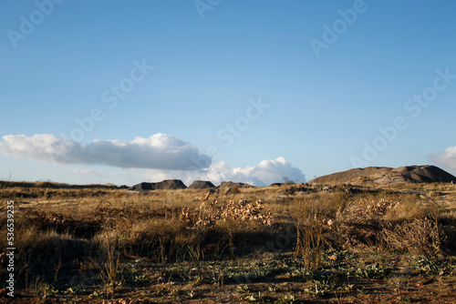 landscape with clouds. Landscape with moutains and clouds hour before sunset. Landscape background with spaces for texts. Blue sky during sunset. Clean blue sky and clouds. Dead grass and drought. © anasphotos2000
