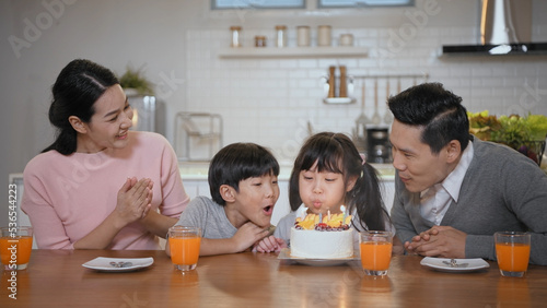 Family concept of 4k Resolution. Asian mom and dad are celebrating their daughter's birthday in the house.