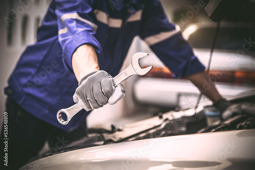 Car care maintenance and servicing, Close-up hand technician auto mechanic holding the wrench to repairing change spare part and fix car engine problem or car insurance service support concepts.