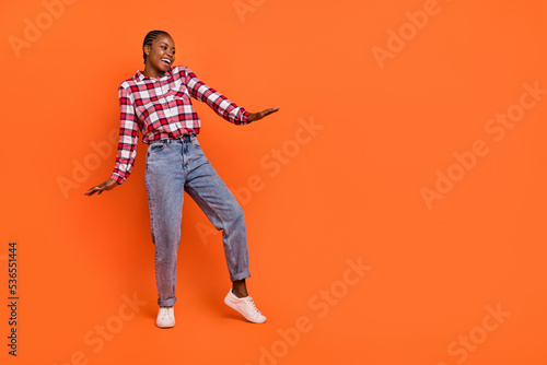Full body portrait of positive pretty girl dancing have good mood isolated on orange color background