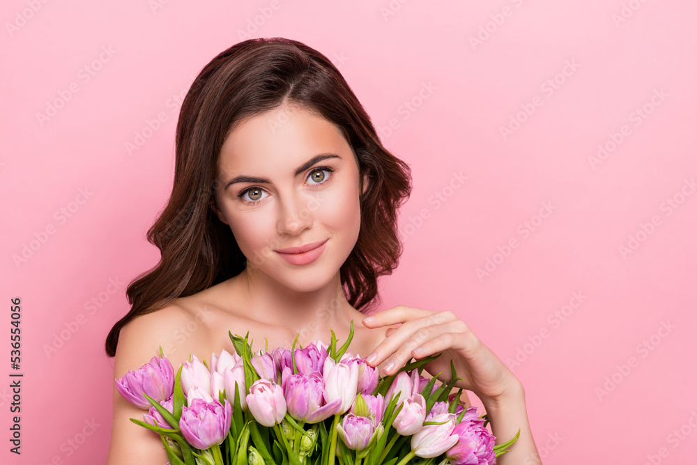 Photo of funny charming young nude lady wear nothing holding tulips bloom empty space isolated pink color background