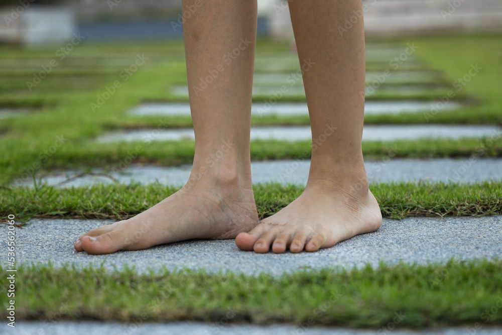 Barefoot little girl walking in garden path