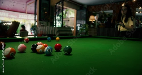 Billiard balls triangle starting position shot. Pool balls with numbers organized in form of pyramid on a green cloth table. white cue ball seen in a distance.Sports game of billiards on green cloth. photo