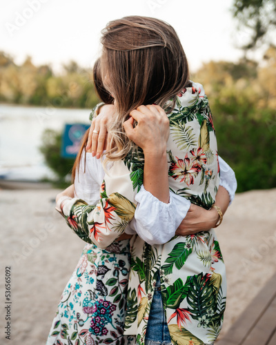 Two beautiful women hug canoodle tightly and sincerely. Friendship, love, summer, happiness, hugging