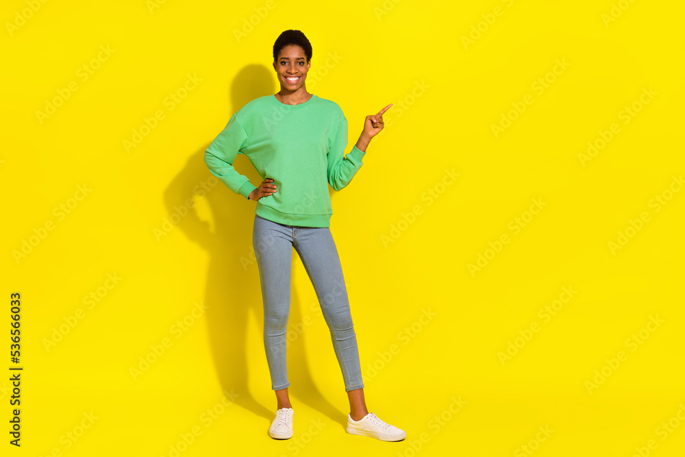 Full length body size view of attractive cheerful girl demonstrating copy space isolated over bright yellow color background Full length body size view of attractive cheerful girl demonstrating copy space isolated over bright yellow color background