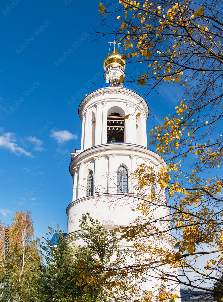 The bell tower of an Orthodox monastery on a sunny day framed by autumn foliage.Bogolyubsky women's monastery. The bell tower of an Orthodox monastery on a sunny day framed by autumn foliage.Bogolyubsky women's monastery.