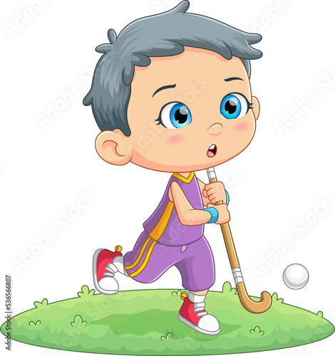 The cute boy is playing field hockey in a garden