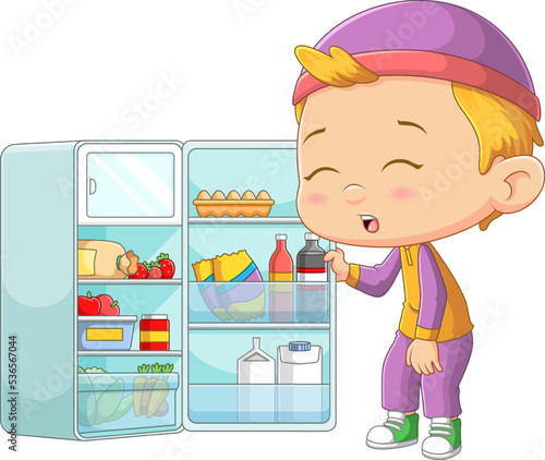 The little boy is very hungry and he opens the refrigerator to take food