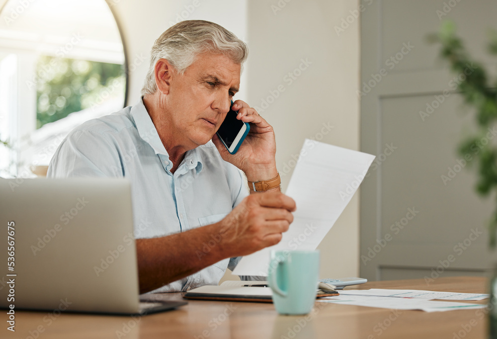 Senior man on a phone call with finance documents for debt counselling. Old male at home with his laptop and paperwork to check finances, accounting and payments, using his mobile phone for help Senior man on a phone call with finance documents for debt counselling. Old male at home with his laptop and paperwork to check finances, accounting and payments, using his mobile phone for help