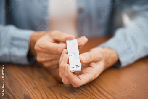 Covid, healthcare and rapid antigen test in the hands of a man at home testing for infection and waiting for results. Health, medical and insurance with a testing kit for corona and examination