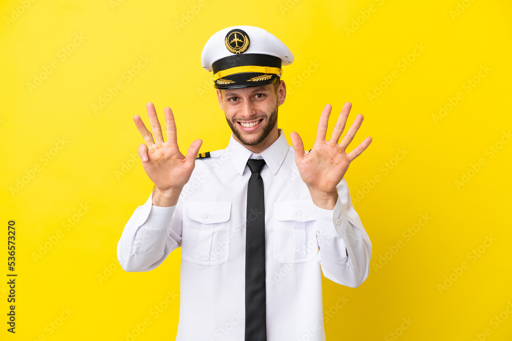 Airplane caucasian pilot isolated on yellow background counting nine with fingers Airplane caucasian pilot isolated on yellow background counting nine with fingers