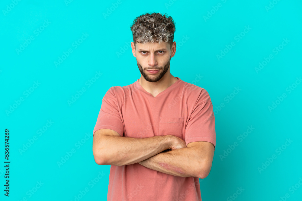 Young handsome caucasian man isolated on blue background with unhappy expression Young handsome caucasian man isolated on blue background with unhappy expression