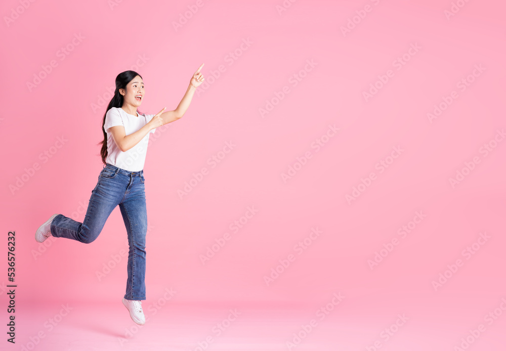 Full body image of Asian girl posing on pink background