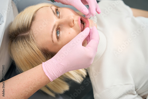 Doctor in pink gloves puts aligners on a patient