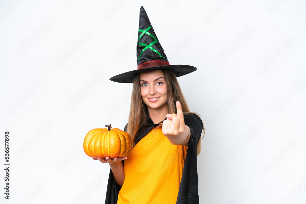 Young caucasian woman costume as witch holding a pumpkin isolated on white background doing coming gesture Young caucasian woman costume as witch holding a pumpkin isolated on white background doing coming gesture