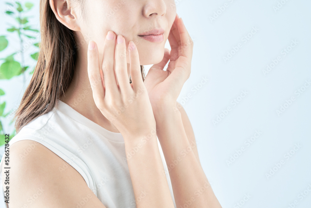 肌の状態を確かめる若い女性 肌の状態を確かめる若い女性