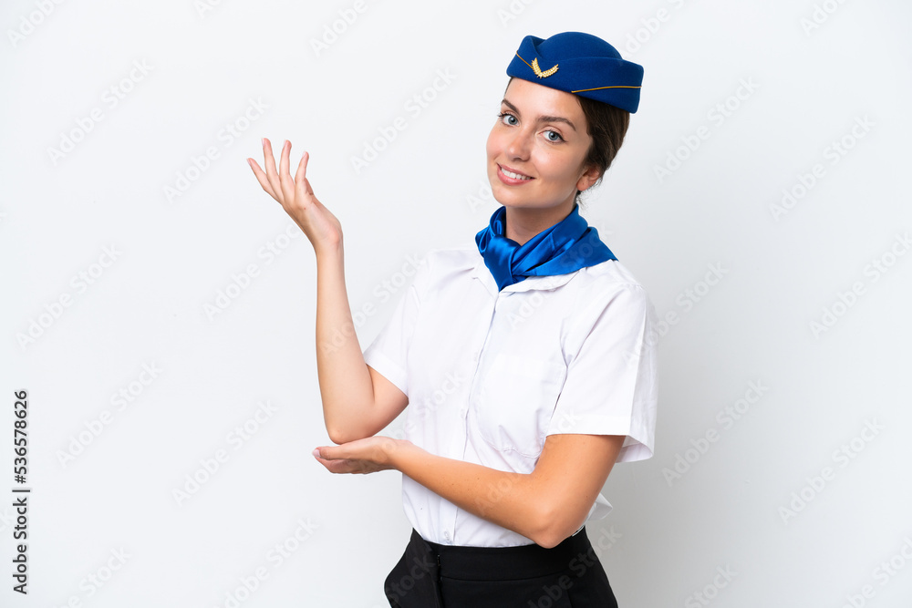Airplane stewardess caucasian woman isolated on white background extending hands to the side for inviting to come Airplane stewardess caucasian woman isolated on white background extending hands to the side for inviting to come