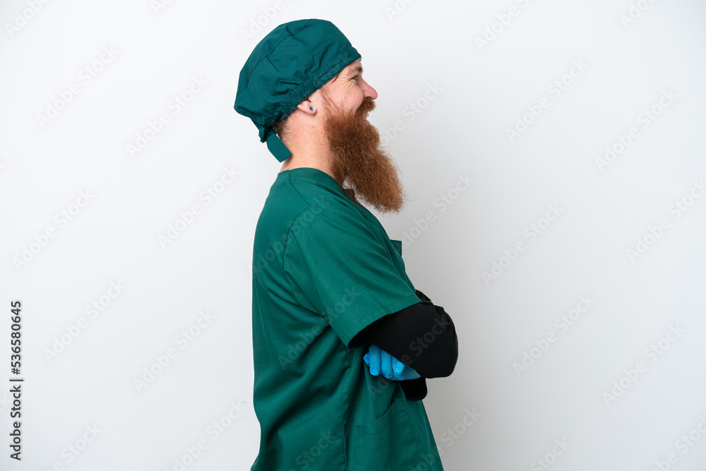 Surgeon redhead man in green uniform isolated on white background in lateral position Surgeon redhead man in green uniform isolated on white background in lateral position