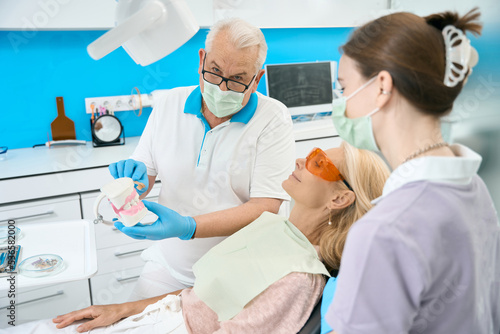 Professional orthodontist explaining correctly treatment above the oral cavity