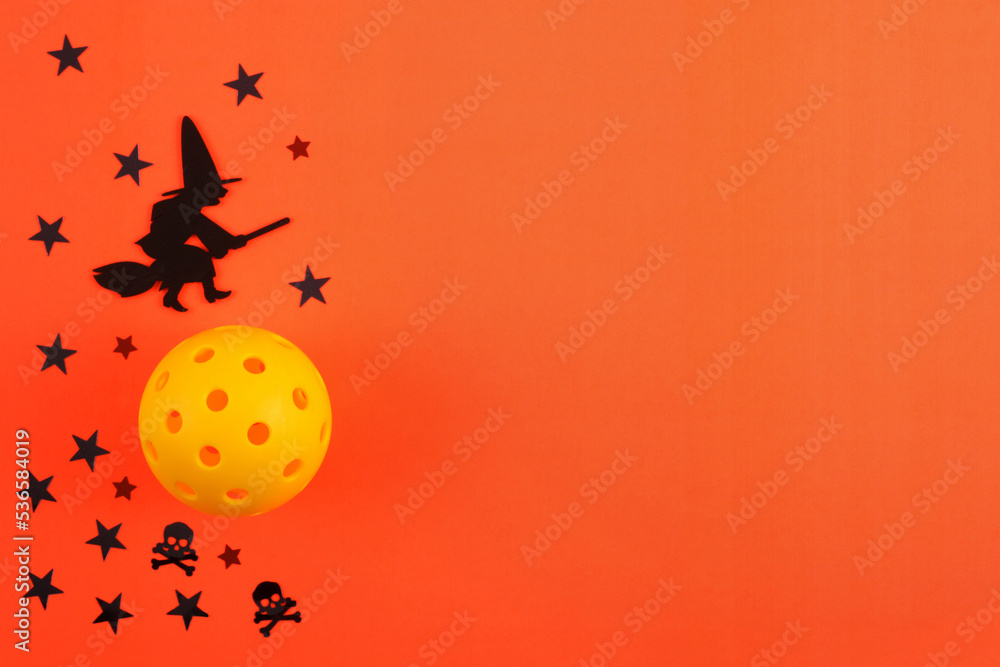 Pickleball Haloween with orange background, yellow Pickleball, black Witch riding broom and stars.  Lots of room for text.