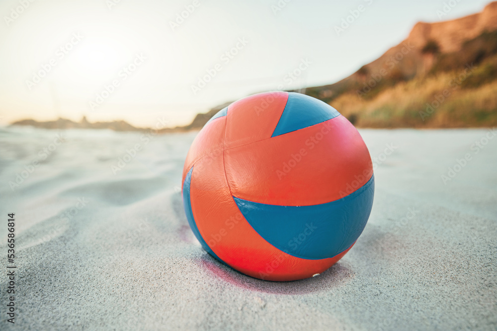 Beach, ball and volleyball on sand, a game at sunset at tropical ocean destination. Fitness, fun and summer sports at the sea in the evening. White sandy coast, a volley ball and an empty seascape.