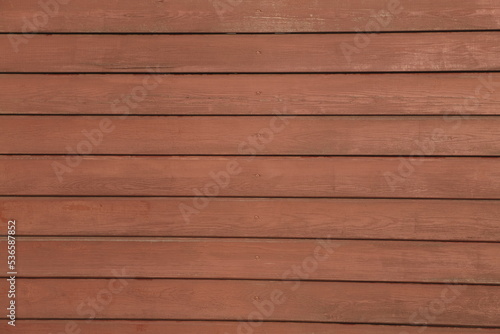 Background of red flaky wood. Backdrop of red colored wooden panels with aged flaky surface