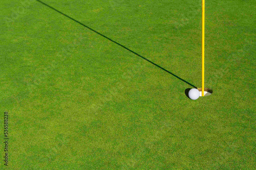 Close-up of Golf Course Green, Flag Pin and Ball.